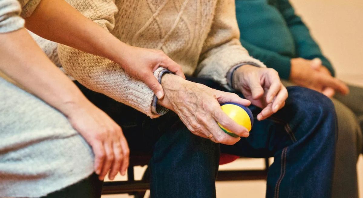 Carer with person holding stress ball